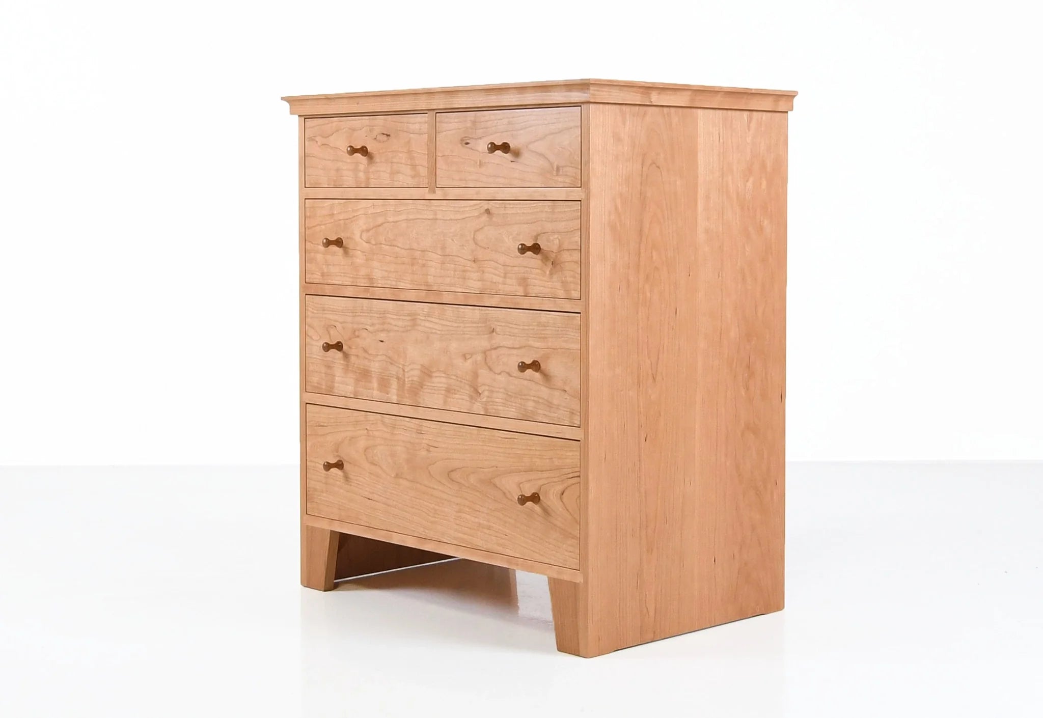 Commode à cinq tiroirs - Conçue dans la tradition, la nôtre est dépourvue d'ornementation, le grain du bois resplendissant sur son