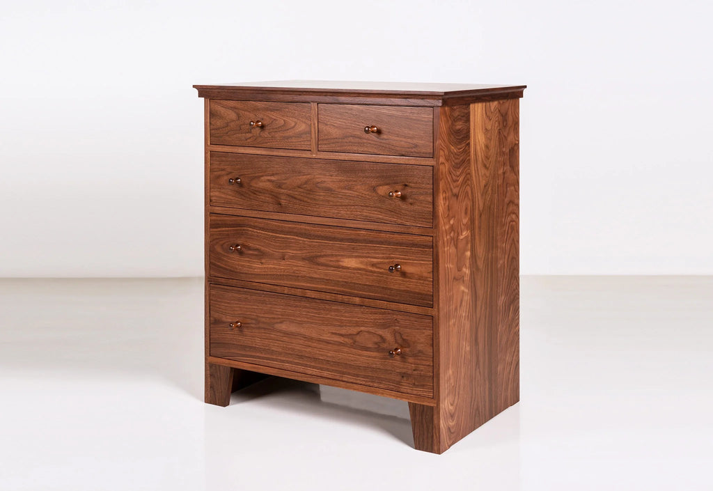 Commode à cinq tiroirs - Conçue dans la tradition, la nôtre est dépourvue d'ornementation, le grain du bois resplendissant sur son
