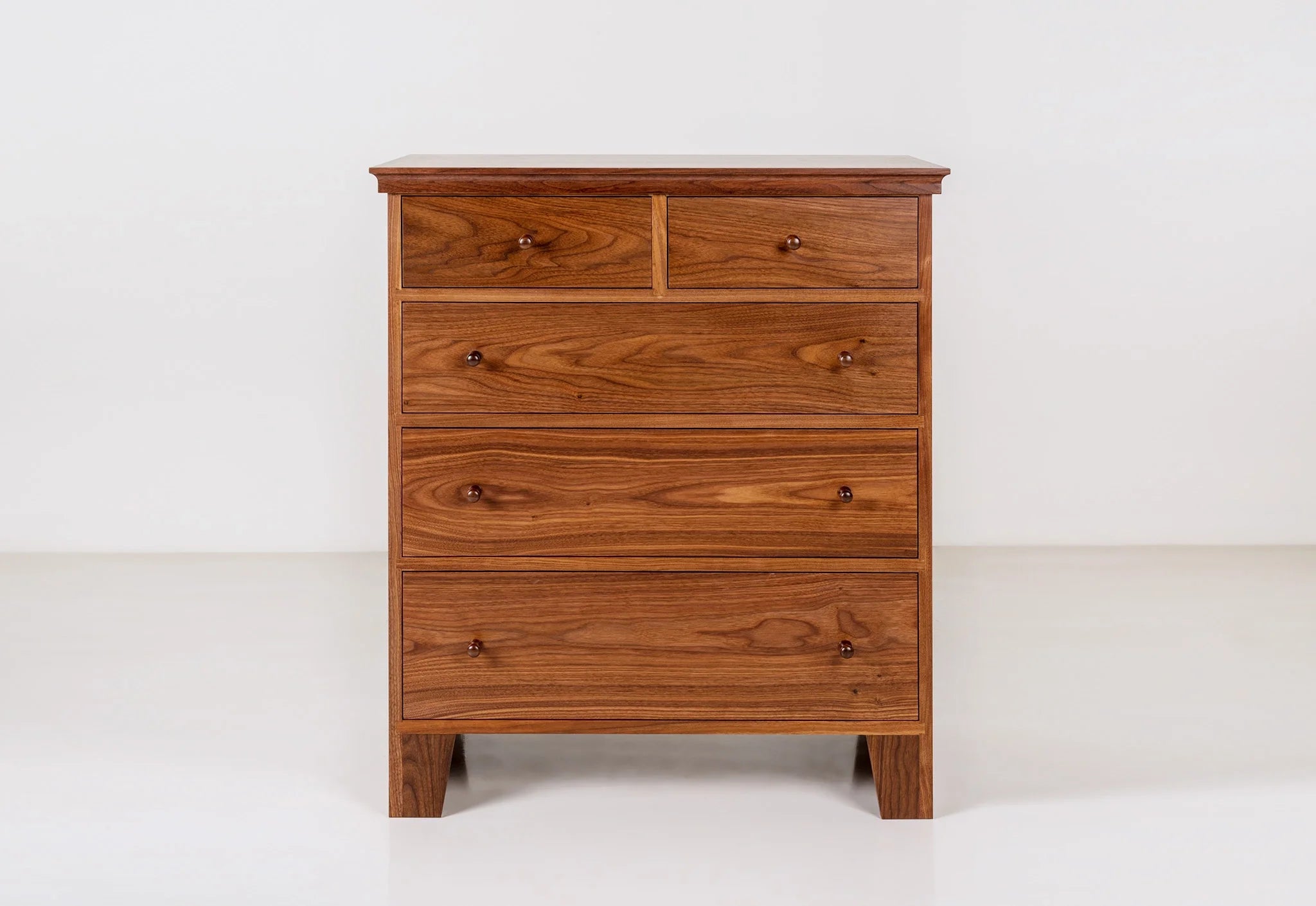 Commode à cinq tiroirs - Conçue dans la tradition, la nôtre est dépourvue d'ornementation, le grain du bois resplendissant sur son