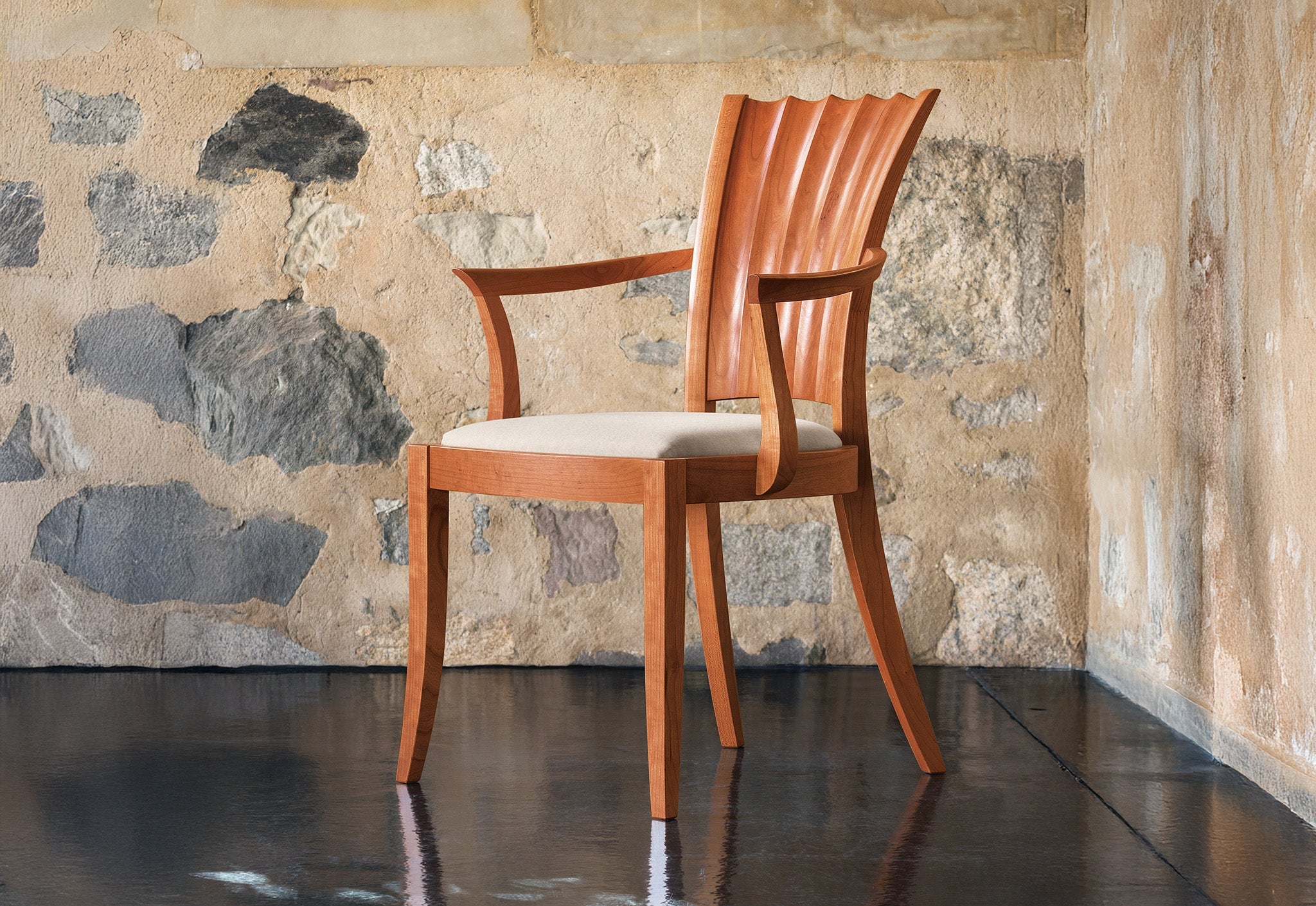 Fauteuil - Les lignes sablier de son dossier unique se dessinent dans les courbes convexes et concaves sculptées à la main.