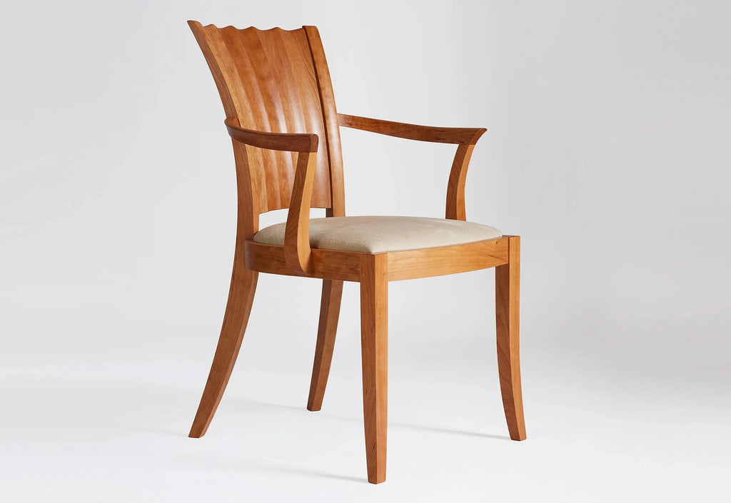 Fauteuil - Les lignes sablier de son dossier unique se dessinent dans les courbes convexes et concaves sculptées à la main.
