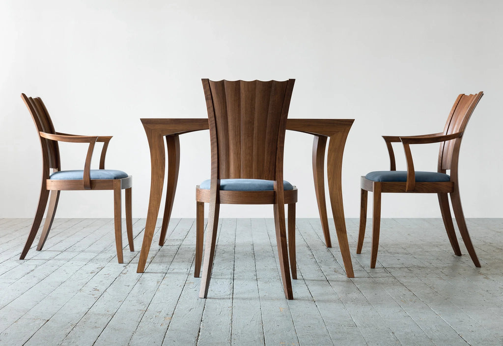 Fauteuil - Les lignes sablier de son dossier unique se dessinent dans les courbes convexes et concaves sculptées à la main.