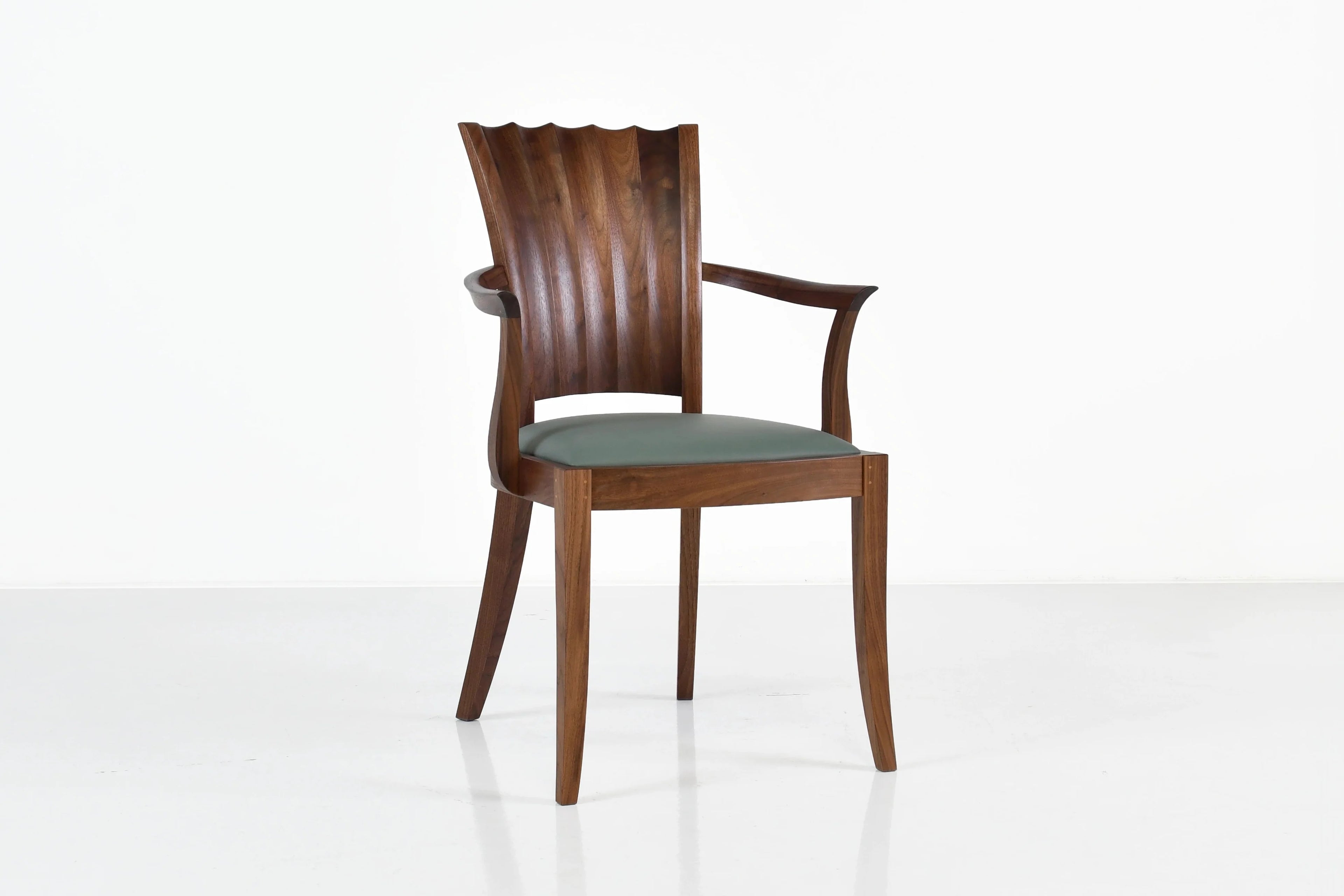 Fauteuil - Les lignes sablier de son dossier unique se dessinent dans les courbes convexes et concaves sculptées à la main.