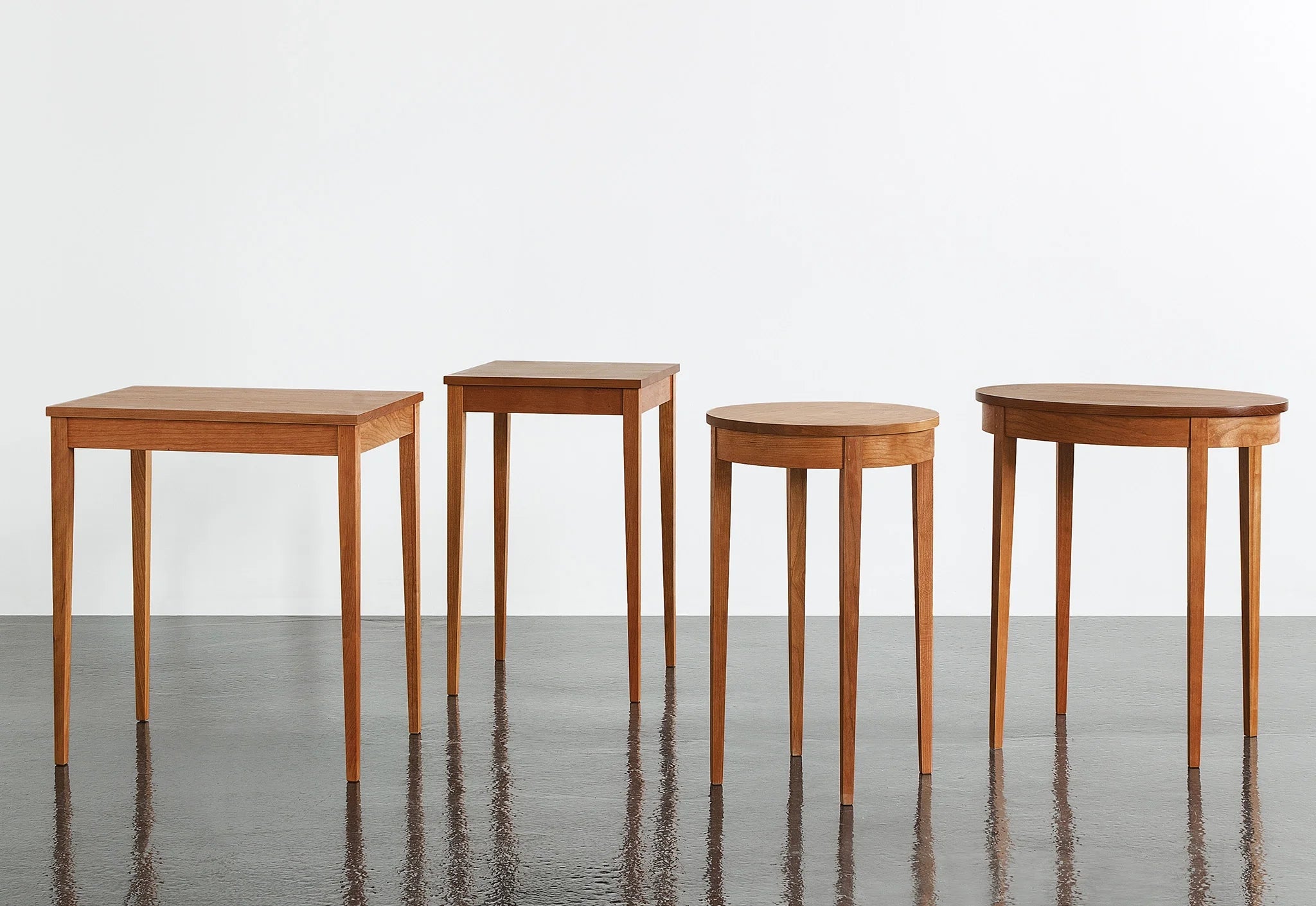 Table Minimus - Inspirées de divers styles, ces tables partagent toutes la même structure de pieds, composée de quatre colonnes fines qui s'élèvent