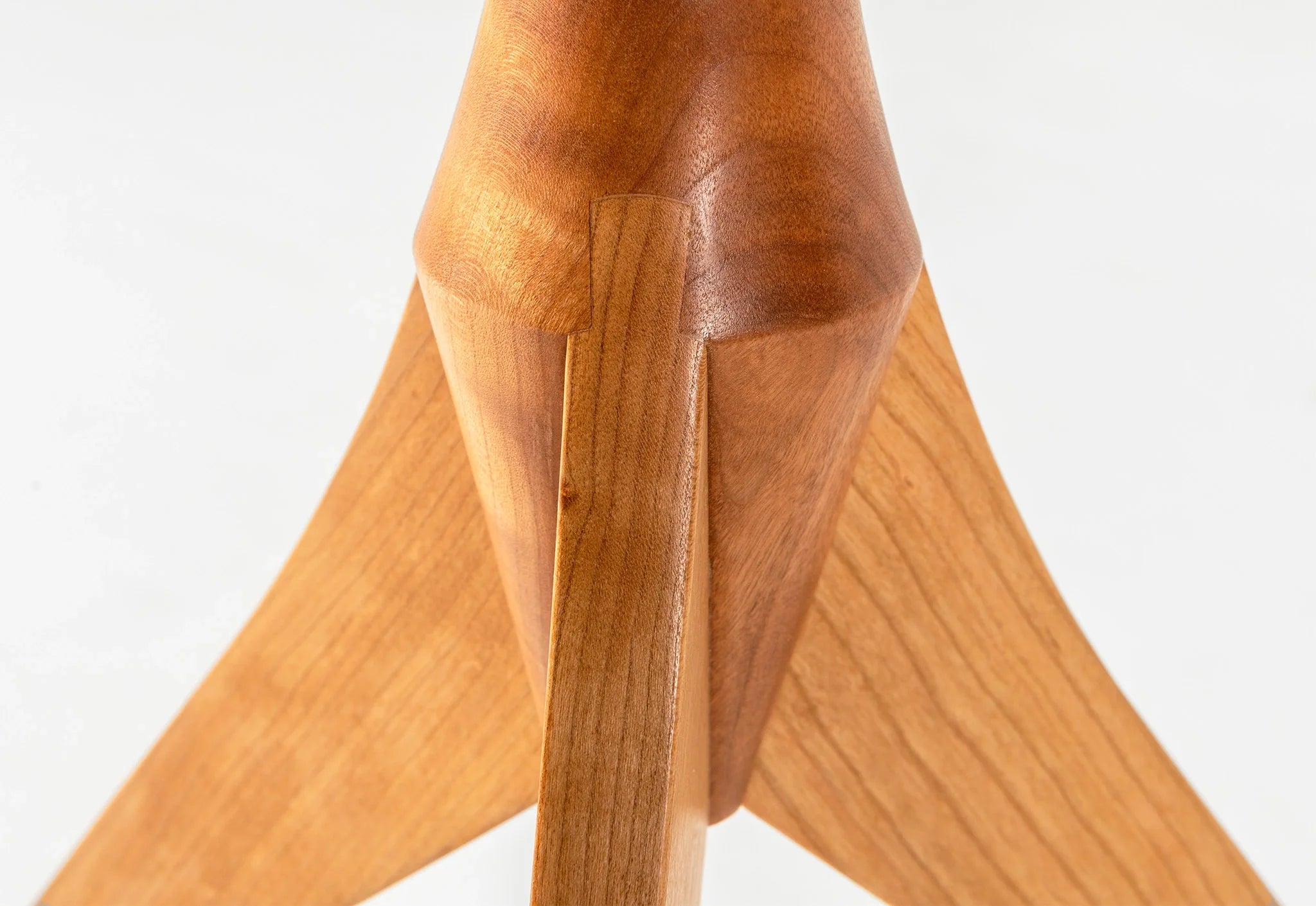 Table - Fabriquée en bois massif, finie à la main, la table est dotée de trois pieds qui s'arquent en s'élevant, formant une inverse