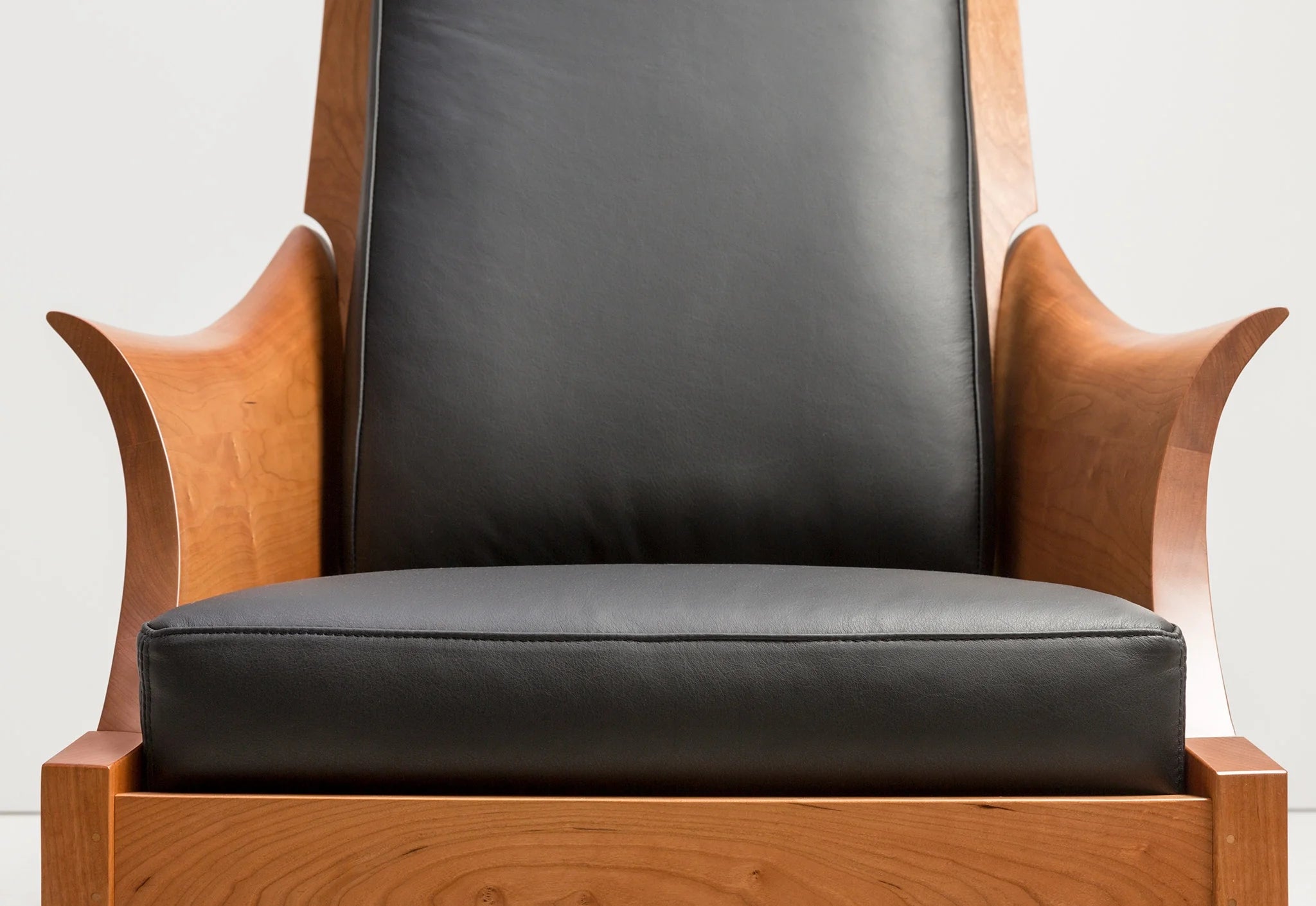 Chaise – Avec des accoudoirs incurvés sculptés dans des blocs de bois à grain assorti, la chaise tire ses origines d'un siège du XVIIIe siècle.