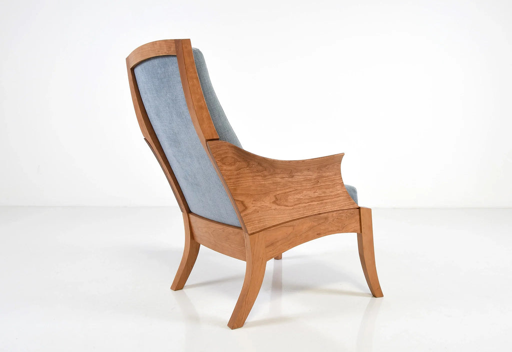 Chaise – Avec des accoudoirs incurvés sculptés dans des blocs de bois à grain assorti, la chaise tire ses origines d'un siège du XVIIIe siècle.