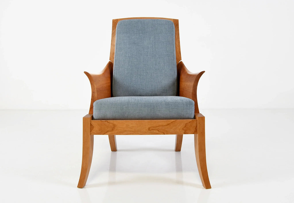 Chaise – Avec des accoudoirs incurvés sculptés dans des blocs de bois à grain assorti, la chaise tire ses origines d'un siège du XVIIIe siècle.