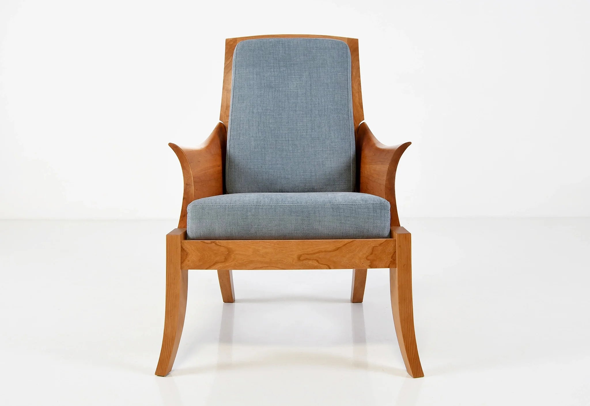 Chaise – Avec des accoudoirs incurvés sculptés dans des blocs de bois à grain assorti, la chaise tire ses origines d'un siège du XVIIIe siècle.